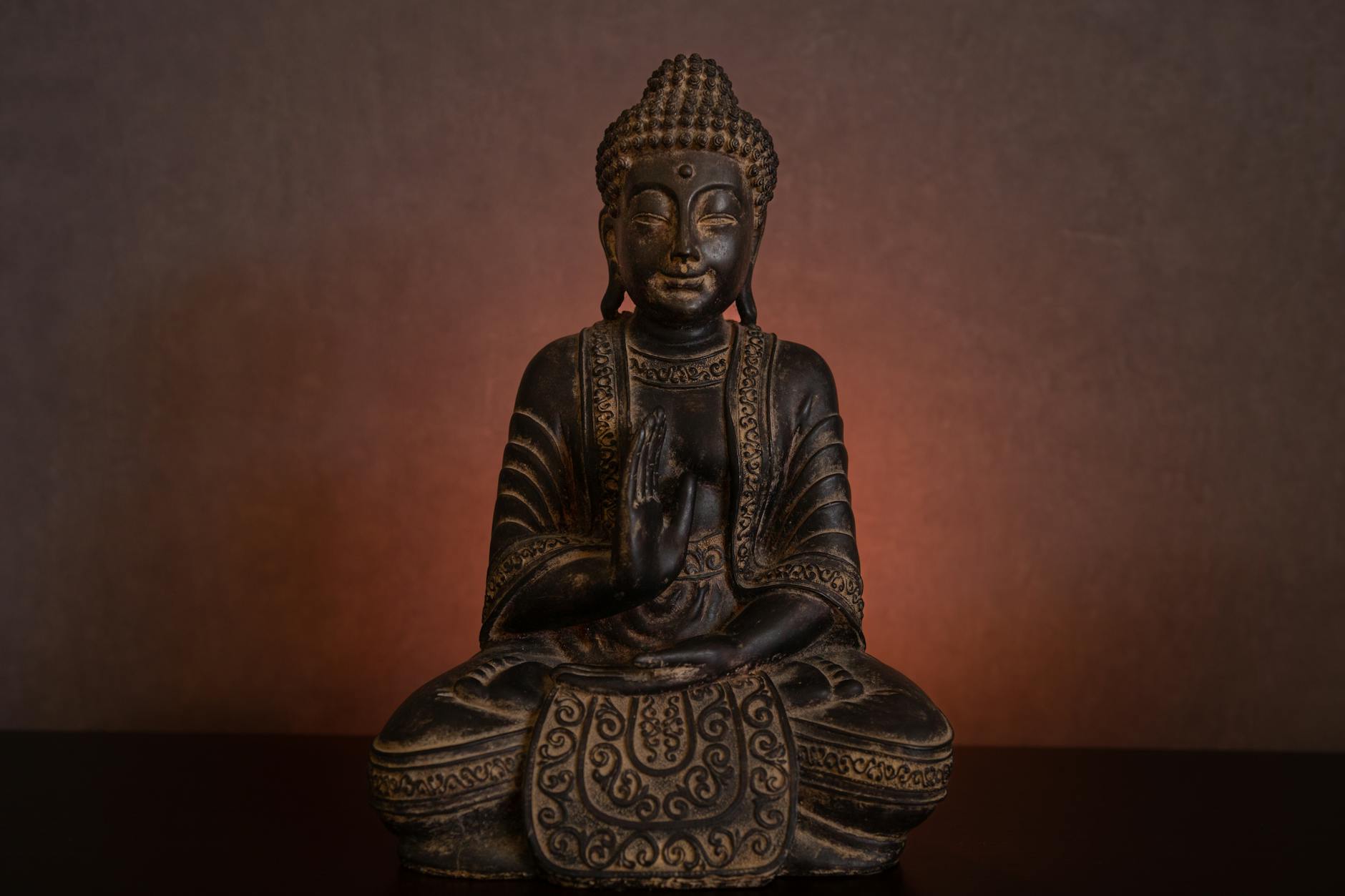 Woman in a graceful yoga pose with golden light accents on a dark background.